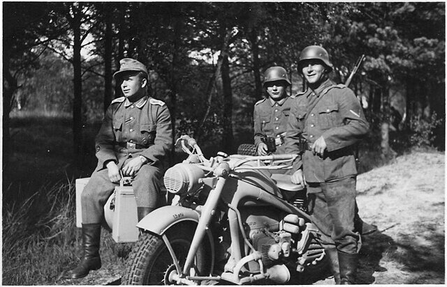 Three German soldiers standing around a Zündapp KS 750
