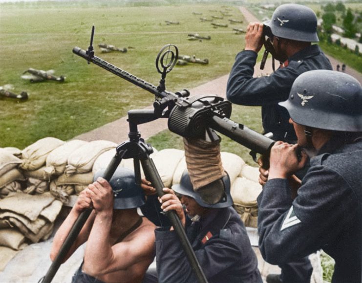 German Luftwaffe machine operators using an anti-aircraft MG-15 gun next to an airfield. Photo: Cassowary Colorizations CC BY 2.0