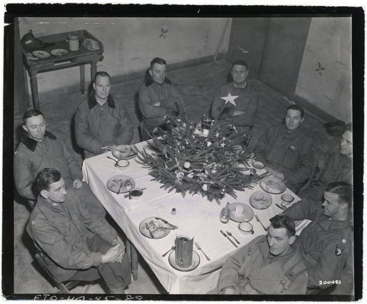 Brigadier General Anthony McAuliffe and his staff gathered inside Bastogne’s Heintz Barracks for Christmas dinner December 25th, 1944.