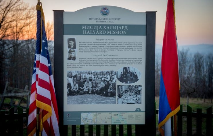The U.S. and Serbian flags are displayed together at an historic marker, detailing a part of Operation Halyard at a ranch in Pranjani, Serbia, Nov. 17, 2016. 