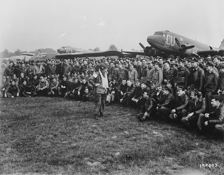 Brigadier General Anthony C. McAuliffe, artillery commander of the 101st Airborne Division, gives his various glider pilots last minute instructions before the take-off on D minus 1.