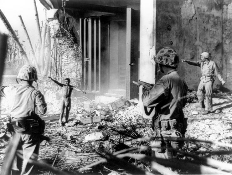 A Japanese soldier surrendering to three US Marines in the Marshall Islands during January 1944.