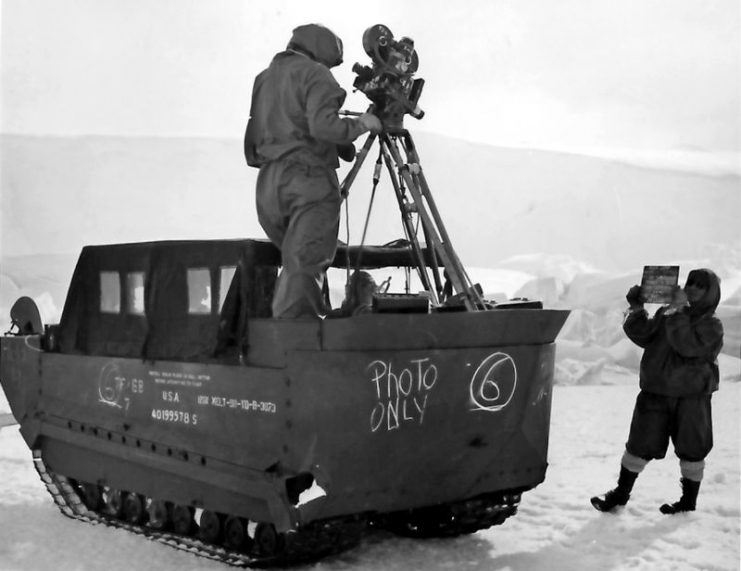 A U.S. Navy photographer’s mate taking a motion picture from a M29 Weasel in Antarctica during Operation Highjump.