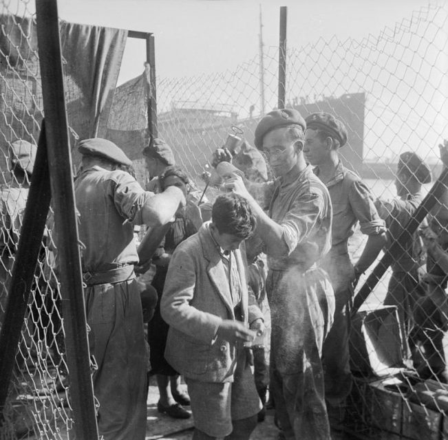 A young Jewish boy immigrant is sprayed with DDT as he is about to board a British troopship for the journey to Cyprus.