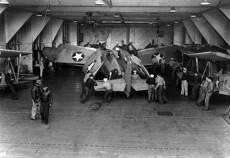 Crewmen spotting F4F-4 Wildcat fighter in Long Island’s hangar deck, 17 June 1942