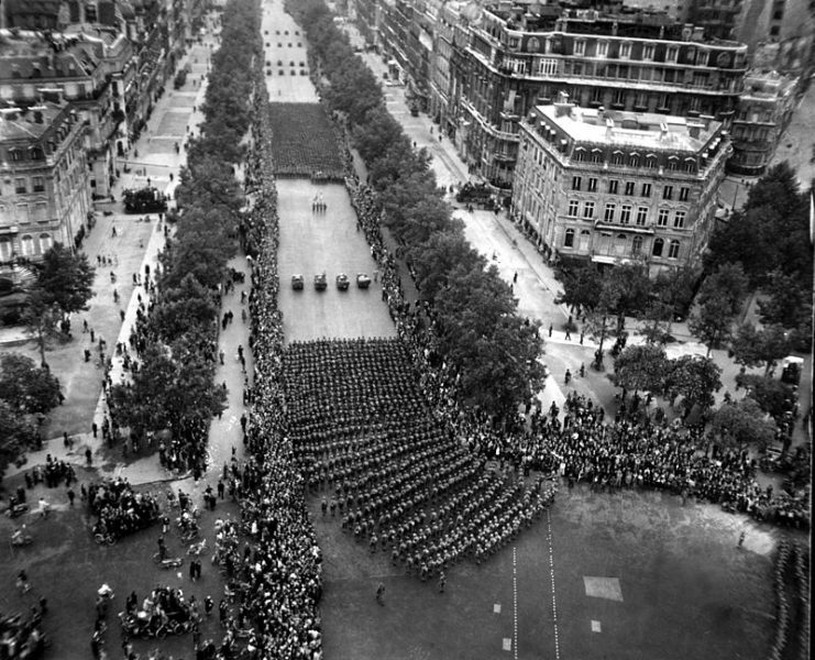 Parisians line the Champs-Elysees to cheer the massed infantry units of the American army as they march in review towards the Arc de Triomphe, celebrating the liberation of the capital of France from Nazi occupation.