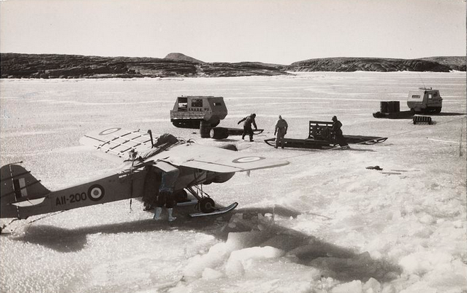 Auster aircraft fitted with skis, weasels and sledges on the fast ice near the Mawson Station in Antarctica