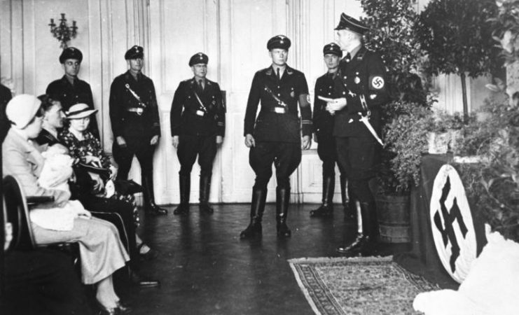 A child’s baptism (christening) ceremony conducted by members of the SS at a “Lebensborn e.V.” maternity care home in Rheinhessen c. 1935–1936.Photo: Bundesarchiv, Bild 146-1969-062A-58 / CC-BY-SA 3.0