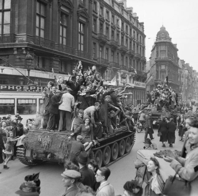 Civilians ride on Cromwell tanks as the British enter Brussels, September 4, 1944.