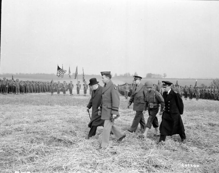 Winston Churchill, Dwight D. Eisenhower and other officials walking past lines of 101st Airborne Division paratroopers