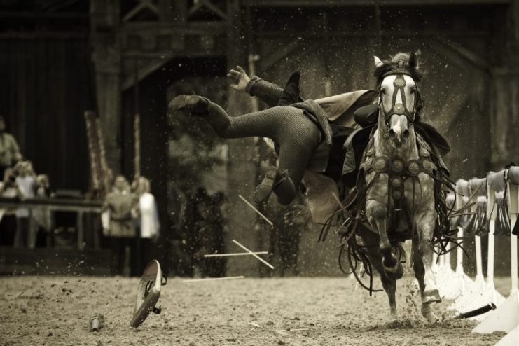 Defeated warrior falling from his horse after losing a jousting battle.