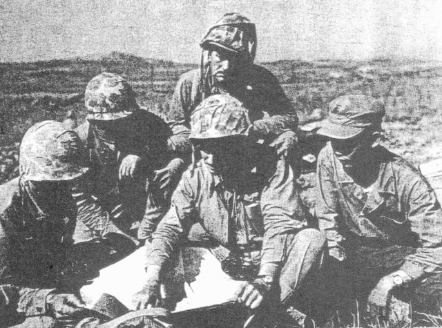 Captain Stevens (center, pointing to map), with his platoon leaders and Korean interpreter, on the outskirts of Seoul. (Photo credit: US Marine Archives)