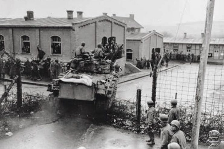 An M4 medium tank crashes into the prison compound at Oflag XIII-B, 6 April 1945 where Bouck was a prisoner of war.