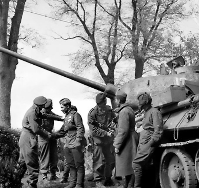 Men of the British 6th Airborne Division greet the crew of a Soviet T-34-85 tank during the link-up of British and Soviet forces near Wismar on the Baltic coast, 3 May 1945.