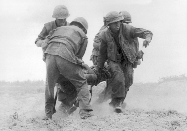 Three US Marines dragging a fourth through the sand