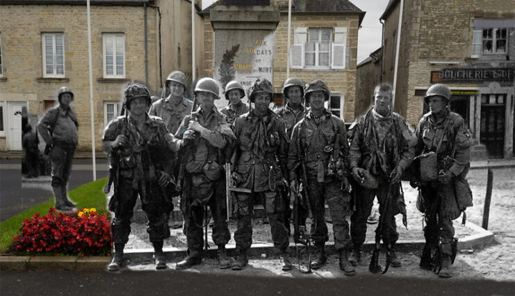 Easy Company and 4th Infantry Division personnel standing in the middle of Sainte-Marie-du-Mont