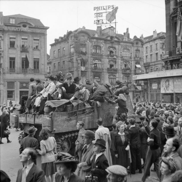 Scenes of jubilation as British troops liberate Brussels, September 4, 1944. Civilians ride on a Sexton self-propelled gun.