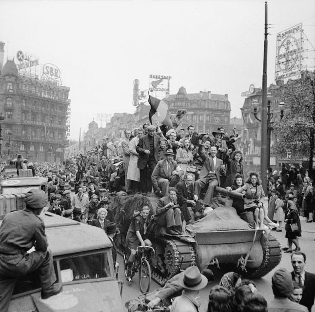 Scenes of jubilation as British troops liberate Brussels, September 4, 1944. Civilians ride on a Sherman tank.