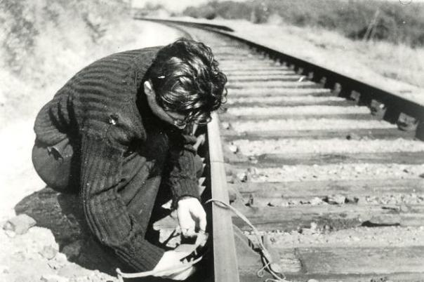 Resistance member setting an explosive charge on a railway line.