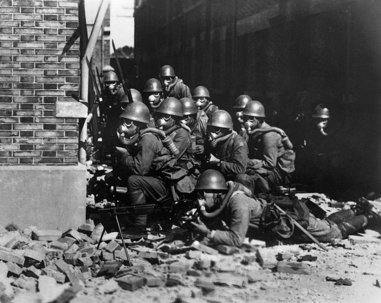 The Imperial Japanese Navy (IJN) Special Naval Landing Forces troops in gas masks prepare for an advance.