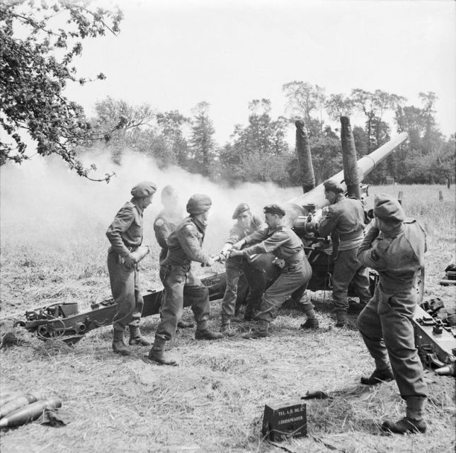 A British 4.5 inch gun being primed ready for firing by men of 211 Battery, 64th Medium Regiment, Royal Artillery near Tilly-sur-Seulles, during the holding operation before the push to Caen.