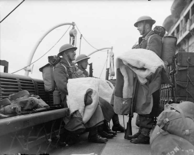 Troops on board a ship bound for Norway carry their newly-issued sheepskin, April 1940.