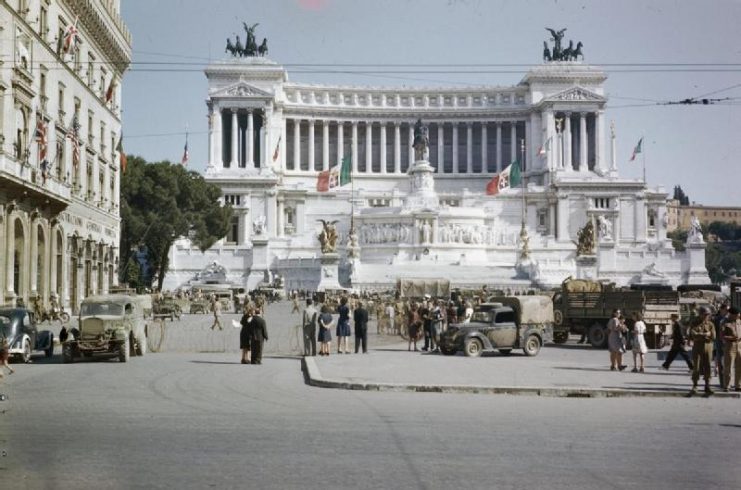 View of the Vittoria Emmanuel memorial and the Piazza Venezia in Rome, with leave party trucks parked in the foreground. In the background is the Unknown Warrior’s Tomb.