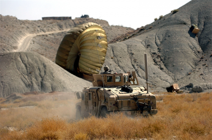 An Army Humvee rushes to the landing site of a supply cargo bundle delivered by one of two C-17 Globemaster IIIs. U.S. Army photo/Spc. Micah E. Clare