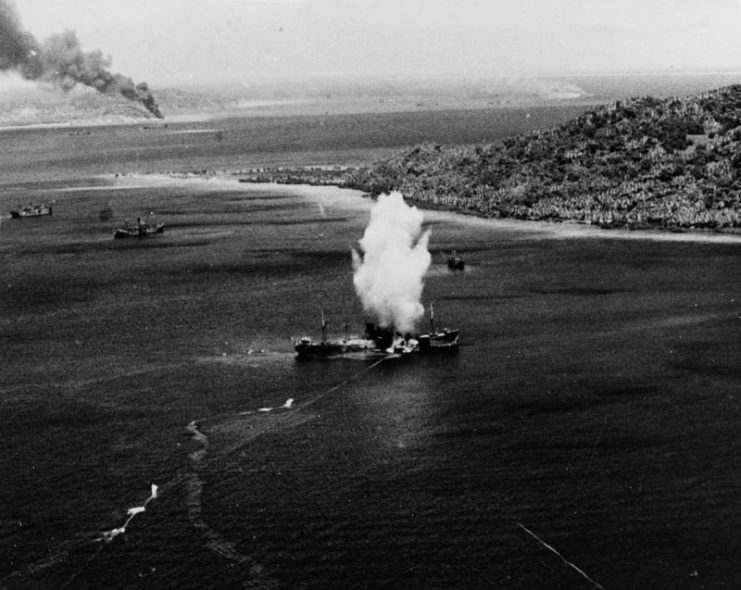 A Japanese freighter in Truk Atoll is hit by a torpedo dropped by a U.S. aeroplane in 1944. By Smith.