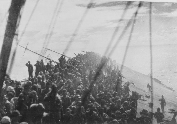 The crew of the Japanese aircraft carrier Zuikaku salute as the flag is lowered during the battle off Cape Engaño, October 25, 1944.