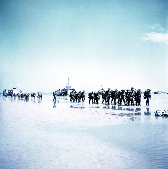 Troops with the 3rd Canadian Infantry Division walking along Juno Beach
