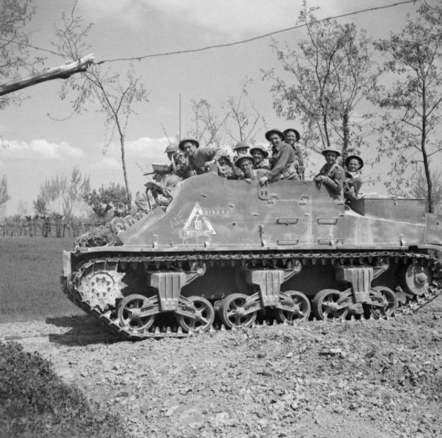 A Priest Kangaroo of 209th Self-Propelled Battery, Royal Artillery, transports infantry of 78th Division near Conselice, Italy, 13 April 1945.
