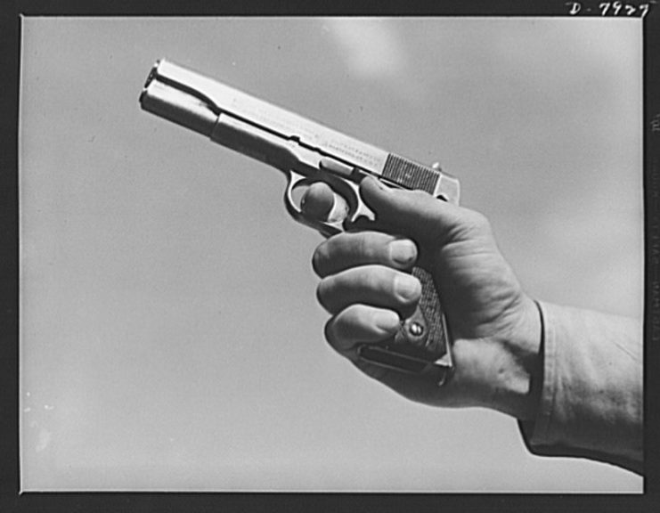 A soldier in training at Fort Knox, Kentucky, demonstrates the use of one of America’s renowned weapons, a Colt pistol.