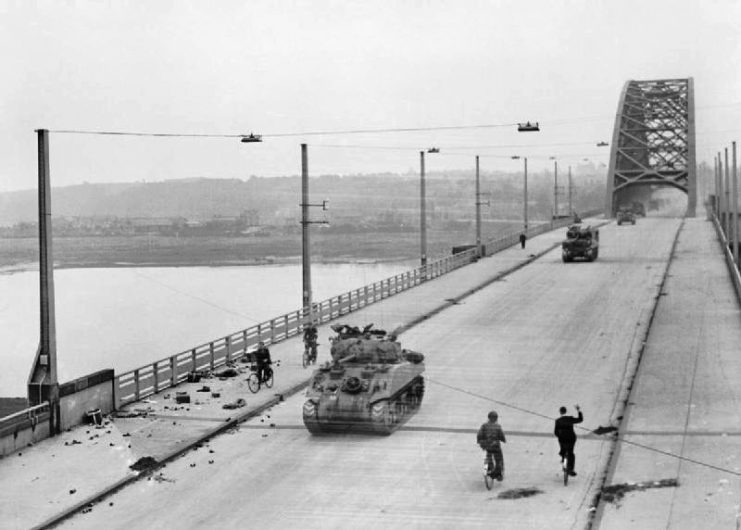 Allied tanks of British XXX Corps cross the road bridge at Nijmegen during its capture.