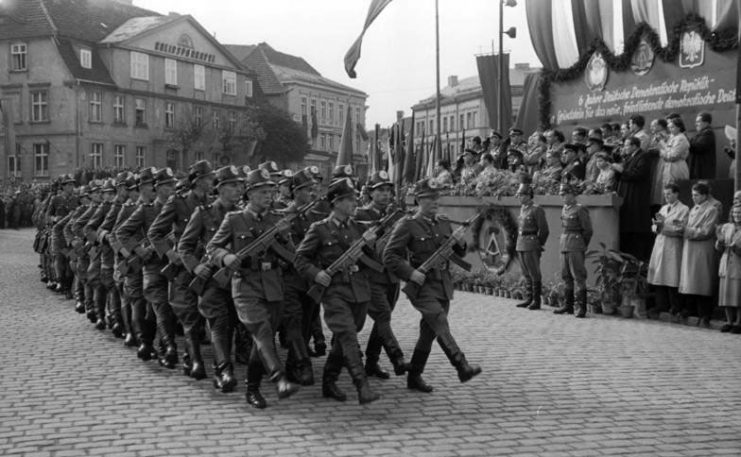 Officers of the East German Volkspolizei parading through the streets of Neustrelitz in 1955. The StG 44 remained in service until the early 1960s. By Bundesarchiv – CC BY-SA 3.0 de