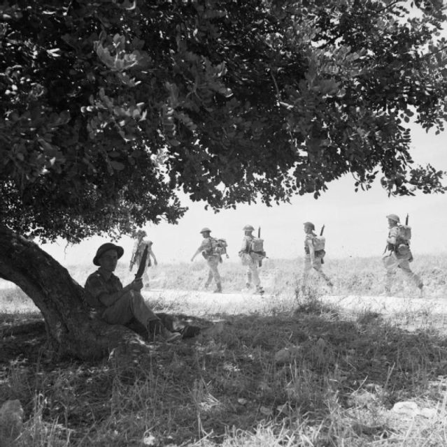 Canadian troops of The Carleton and York Regiment move inland from the beaches after landing in Sicily, July 13, 1943.