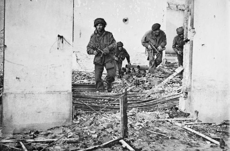 Four British paratroopers moving through a shell-damaged house in Oosterbeek to which they had retreated after being driven out of Arnhem.