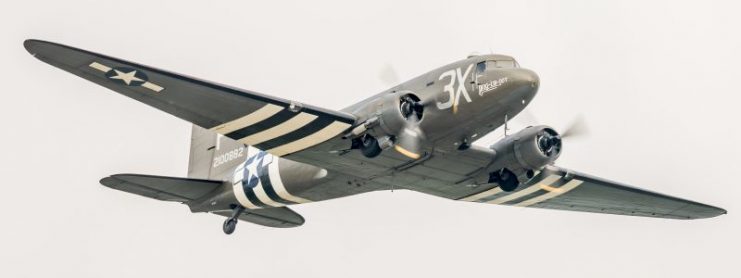 Duxford, UK – May 28, 2016: a Douglas C-47 Skytrain / Dakota US military transport aircraft of WW2 seen in flight over Cambridgeshire, England.