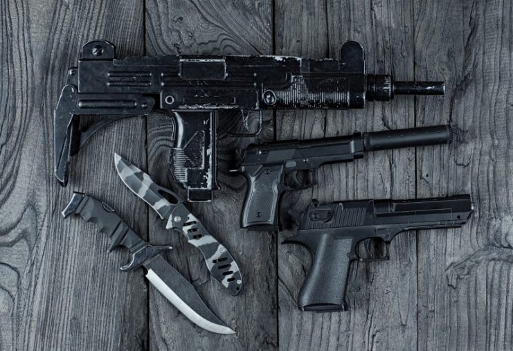 Uzi submachine gun among other guns and knives.