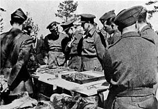 British, Canadian, and American officers (POWs) brought by the Germans to view the exhumations.