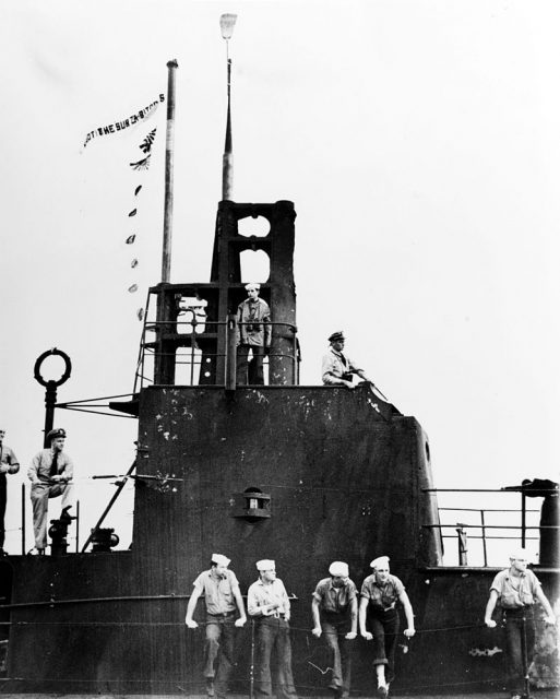 The U.S. Navy submarine USS Wahoo (SS-238) at Pearl Harbor, Hawaii (USA), soon after the end of her third war patrol, circa 7 February 1943. Her Commanding Officer, Lieutenant Commander Dudley W. Morton, is on the open bridge, in right center.