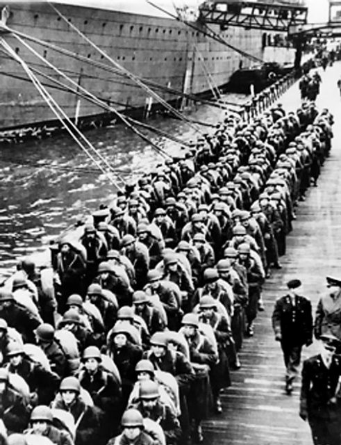 US troops waiting on a pier at a harbour in England – 5 June 1944