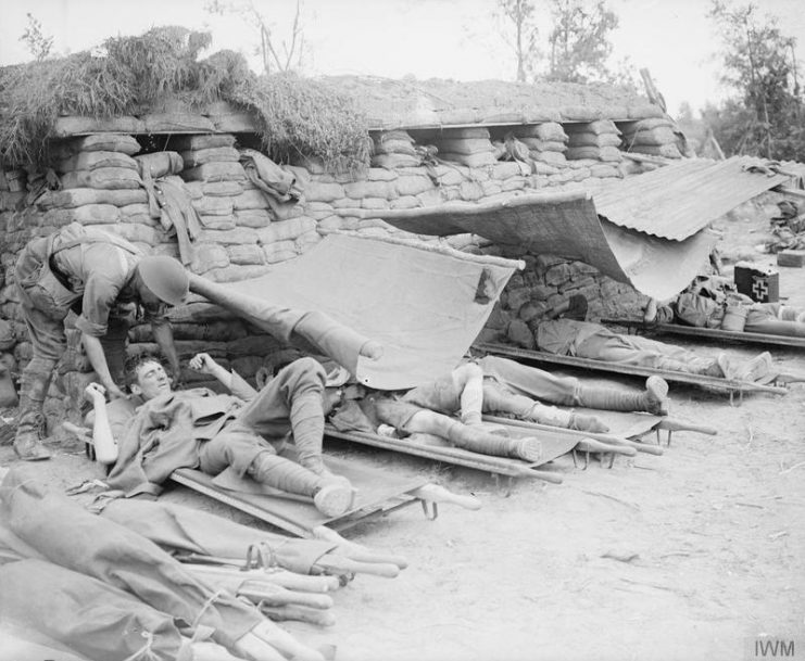 Wounded soldiers on stretchers under an awning near Messines, June 7, 1917
