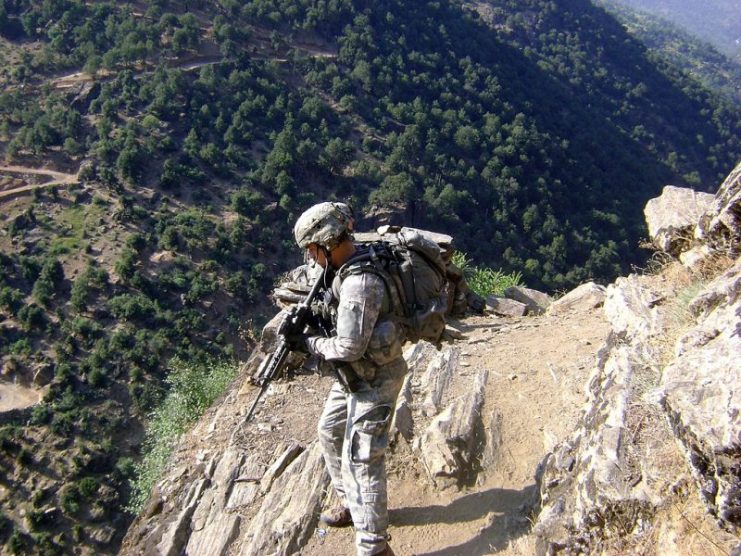 U.S. Army Staff Sgt. Clinton L. Romesha patrols near Combat Outpost Keating in Kamdesh, Nuristan province, Afghanistan, 27 July 2009.