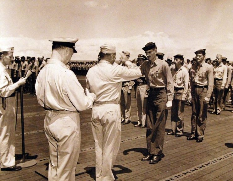 Rear Admiral Ralph Davidson presenting the Purple Heart to personnel onboard the carrier, USS Wasp (CV 18), July 7, 1944.
