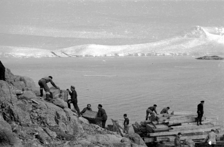 Offloading stores to establish Base A at Port Lockroy, 1944. (Photographer: Ivan Mackenzie Lamb; Reproduced courtesy of the British Antarctic Survey Archives Service. Archives ref: AD6/19/1/A1/29). Copyright: Crown (expired).