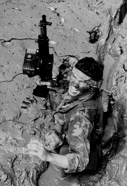 SEAL team member moves through deep mud as he makes his way ashore from a boat, during a combat operation in South Vietnam, May 1970. His gun is a MK 23 5.56mm machine gun (Stoner 63). Note his camouflage uniform and face paint