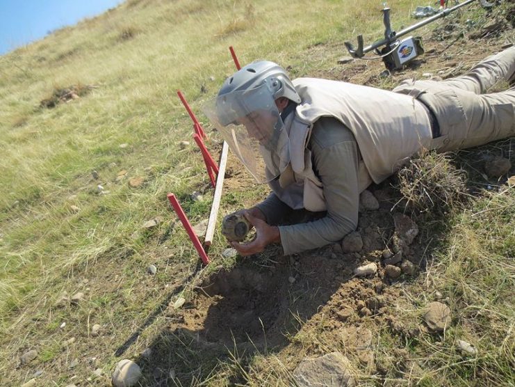 A deminer from the non-governmental organization MAG (Mines Advisory Group) disarms a VS-50 anti-personnel landmine. Photo: MAG CC BY 4.0