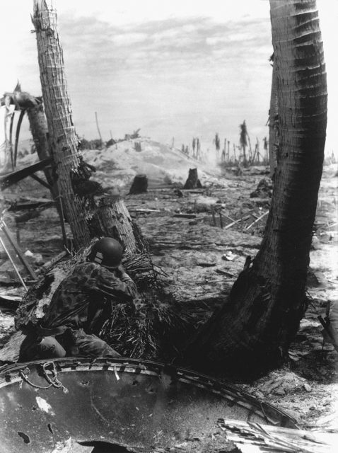 A Marine fires on a Japanese pillbox.