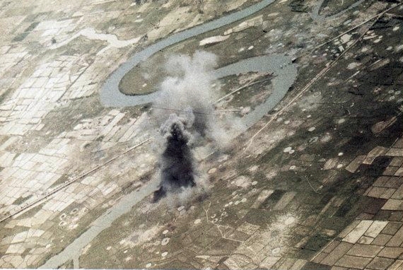 A U.S. Navy strike photograph from Carrier Air Wing 21 (CVW-21) showing burning supply barges in North Vietnam